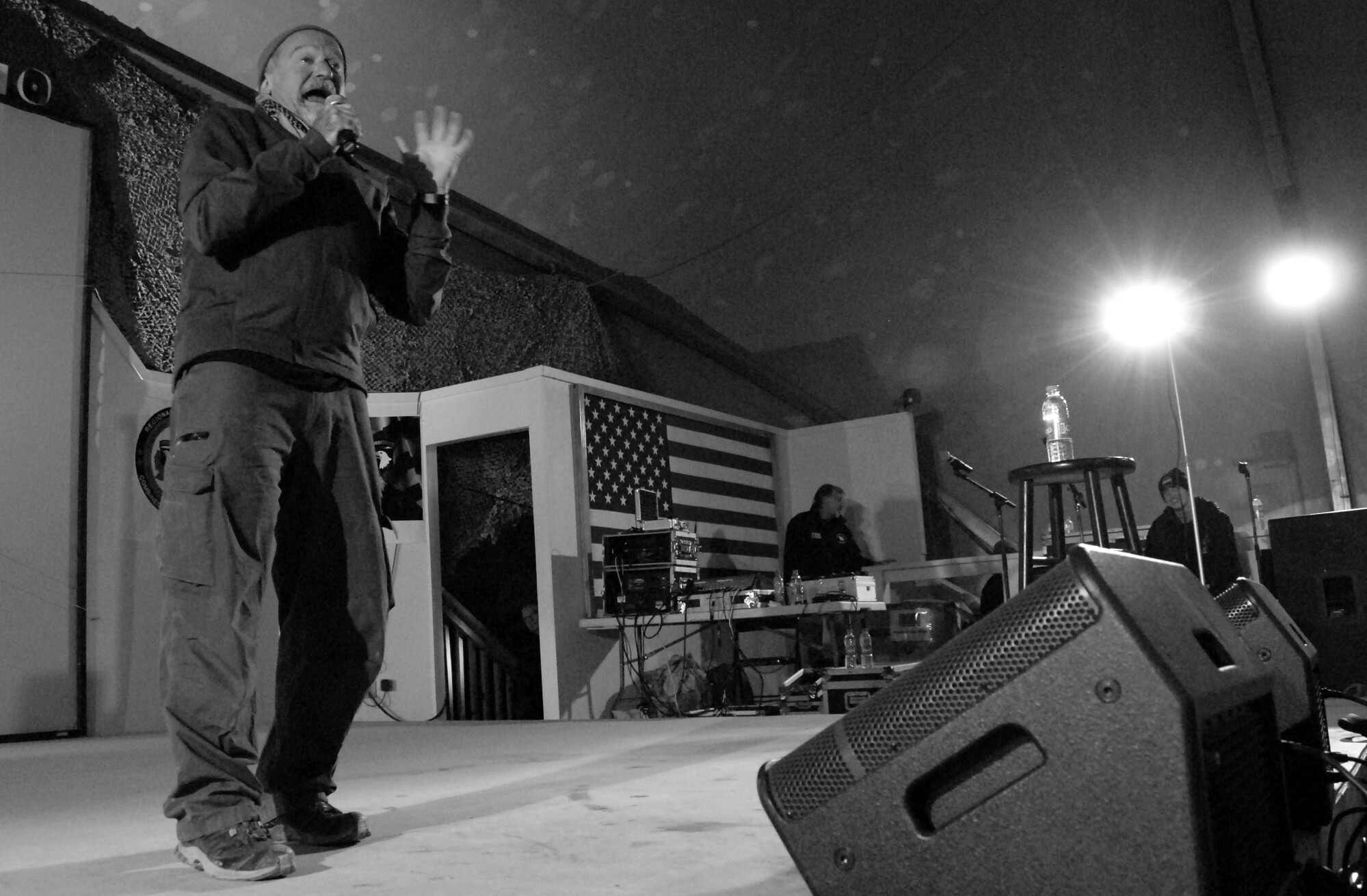 Robin Williams performs for service members during a 2010 USO holiday tour at Bagram Air Field, shown in black and white
